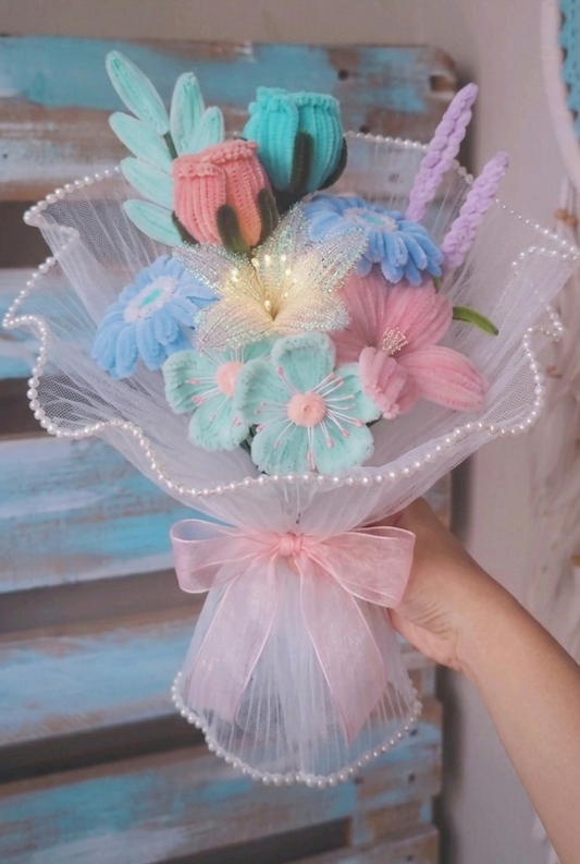 Colorful flower bouquet with a pink bow held by a hand against a wooden background